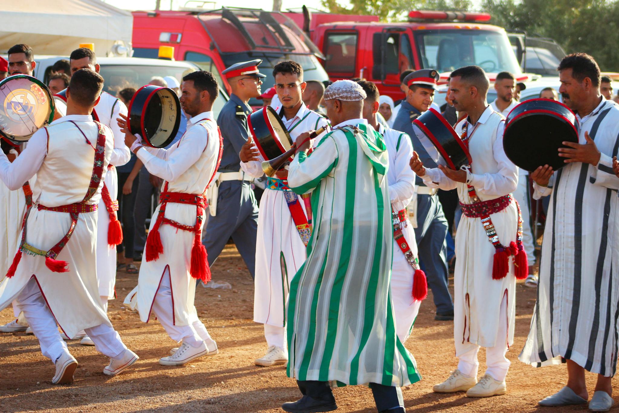 Men in traditional attire playing drums at a festival in Fès-Meknès, Morocco.